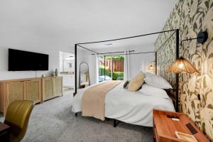 Leucadia's Beach House w Game Room في إنسينيتاس: غرفة نوم مع سرير كبير وتلفزيون