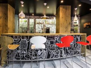 eine Bar mit roten Stühlen und einer schwarz-weißen Wand in der Unterkunft IBIS La Rochelle Vieux Port Centre in La Rochelle + 45 Fotos