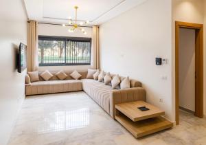 a living room with a couch and a table at Cozy Apartment Near Airport in Nouaceur