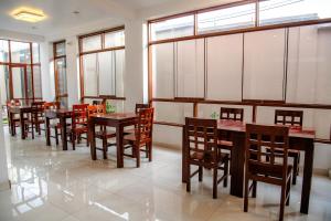 a restaurant with wooden tables and chairs and windows at HOTEL TERRANOVA Abancay in Abancay