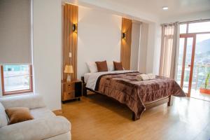 a bedroom with a bed and a chair and a couch at HOTEL TERRANOVA Abancay in Abancay