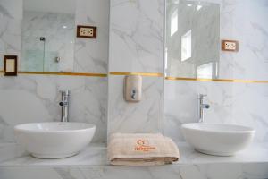 a white bathroom with two sinks and a mirror at HOTEL TERRANOVA Abancay in Abancay