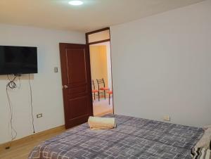 a bedroom with a bed and a flat screen tv at Departamento AQP in Arequipa