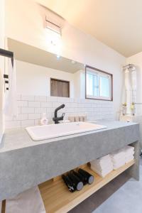 a bathroom with a large sink and a mirror at Casa Katatsumuri in Nakafurano +88 photos