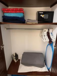 a small room with a shelf with towels and a bed at Cocomarindo Breeze Condo and Amazing Pool in Coco