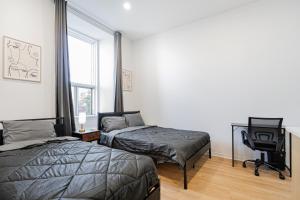 een slaapkamer met twee bedden, een bureau en een stoel bij Central Studio For 3 Guest With Parking in Montreal