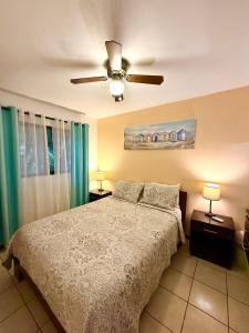 ein Schlafzimmer mit einem Bett und einem Deckenventilator in der Unterkunft Cocomarindo Breeze Condo and Amazing Pool in Coco