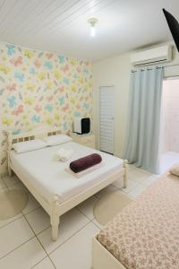 ein Schlafzimmer mit einem Bett und einer Wand mit Blumen in der Unterkunft ꕥ Casa Premium com 9 Lugares ꕥ Cantinho da Margarida ꕥ Hospedagem & Hostel Premium in Belém