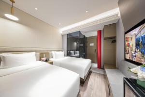 a hotel room with a white bed and a tv at Mercure Beijing Tiananmen Square Qianmen Street in Beijing