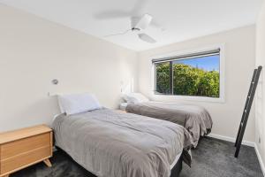 zwei Betten in einem Zimmer mit Fenster in der Unterkunft Vista Serena in Pohara