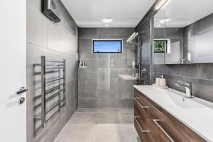 ein Badezimmer mit einem Waschbecken und einer Badewanne sowie einem TV in der Unterkunft Vista Serena in Pohara + 2 Fotos