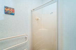 a shower with a glass door in a bathroom at Hosts on the Coast Paws & Relax Bach in Hahei +34 photos