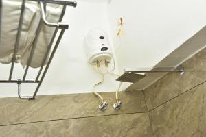 a hair dryer hanging from a wall in a bathroom at DOWN TOWN HOLIDAYS Kovalam in Kovalam +50 photos