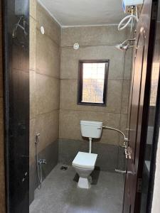 Un baño con inodoro y ducha con ventana. en Hostelwale, en Pune