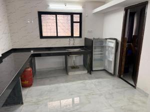 una cocina con fregadero y refrigerador en Hostelwale, en Pune