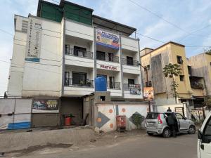un edificio con un coche aparcado delante en Hostelwale, en Pune