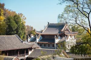 a large building with roofs with trees in the background at The Meixi Lake, Changsha Marriott Executive Apartments in Changsha
