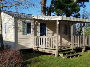 una piccola casa con portico e recinzione di Mobil-home confortable avec terrasse pour 4 personnes à Tréguennec - API-1-52-1029 a Tréguennec