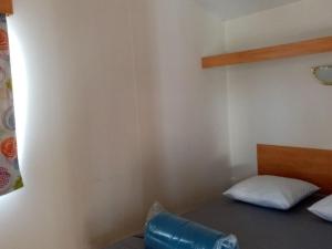 una stanza con un letto con una botte blu sopra di Mobil-home confortable avec terrasse pour 4 personnes à Tréguennec - API-1-52-1029 a Tréguennec Altre 27 foto