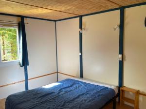 Schlafzimmer mit blauem Bett und Holzdecke in der Unterkunft Chalet 5 pers - PMR - Terrasse spacieuse - API-1-52-1017 in Dolus d'Oléron + 20 Fotos