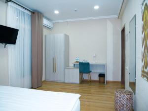 a bedroom with a bed and a desk and a chair at Oasis Boutique in Bukhara