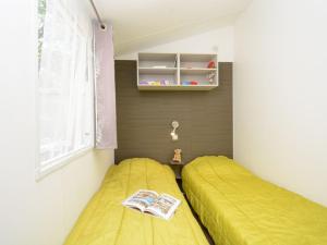 Un dormitorio con una cama amarilla y una ventana. en Mobil-home PMR avec Terrasse à Hyères - API-1-52-1030, en La Decapris