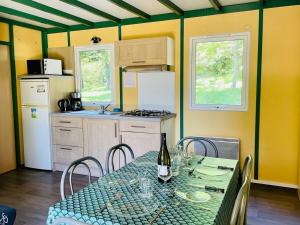 a kitchen with a table with a bottle of wine at Chalet Confort 6 Pers - Terrasse - API-1-52-1032 in Belloc