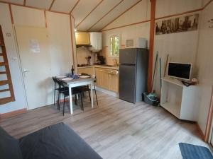 a small kitchen with a table and a refrigerator at Chalet de 28m² pour 4 personnes avec terrasse - API-1-52-1035 in Garindein