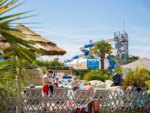 eine Gruppe von Personen, die in einem Wasserpark auf Stühlen sitzen in der Unterkunft Mobil Home Prestige avec Terrasse à Saint-Jean-de-Monts - API-1-52-1055 in Notre-Dame-de-Monts