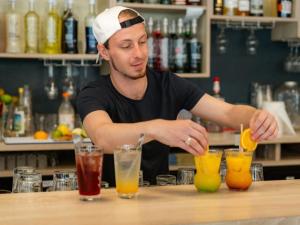 Ein Mann mixt Cocktails an einer Bar in der Unterkunft Mobil Home Prestige avec Terrasse à Saint-Jean-de-Monts - API-1-52-1055 in Notre-Dame-de-Monts