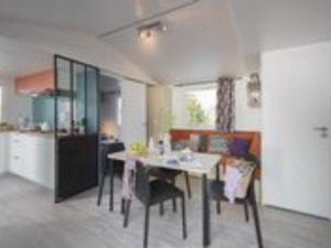 a kitchen and dining room with a table and chairs at Mobil-home cosy avec terrasse pour 5 personnes - API-1-52-1066 in Saint-Rome-de-Tarn