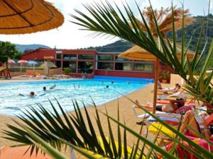 a swimming pool with people in a resort at Mobil-home cosy avec terrasse pour 5 personnes - API-1-52-1066 in Saint-Rome-de-Tarn