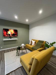 基扬古尔Charmant T2 équipé Proche Versailles的客厅里有一张黄色沙发和一台电视