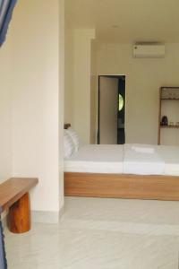 a bedroom with a large white bed with a mirror at Hiên's Homestay in Kon Rung (1)