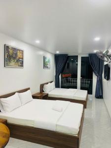 a bedroom with two beds and a window at Hiên's Homestay in Kon Rung (1) +24 photos