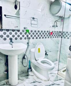 a bathroom with a toilet and a sink at MGallery Hotel in Srinagar