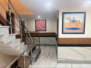 a hallway with stairs and a painting of a horse on the wall at MGallery Hotel in Srinagar