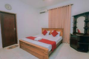 Un dormitorio con una cama con almohadas rojas y blancas. en Hamilton View, en Negombo 10 fotos más
