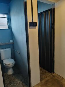 a bathroom with a toilet in a blue room at travellersloft 168 in Johor Bahru +5 photos
