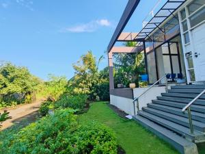 ein Haus mit Glastüren und einer Treppe an der Seite in der Unterkunft Green Courtyard Luxury Villa in Badlapur