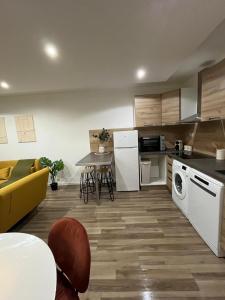 基扬古尔Charmant T2 équipé Proche Versailles的配有沙发和桌子的厨房和客厅