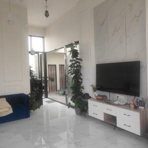 a living room with a flat screen tv on a wall at Green Courtyard Luxury Villa in Badlapur +74 photos