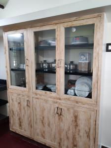 a wooden cabinet with dishes inside of it at The Sparrow House 1BHK First Floor in Kumbakonam