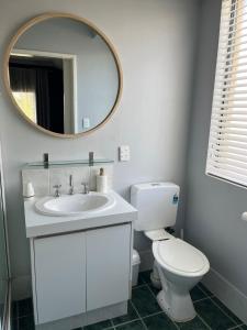 a bathroom with a white toilet and a mirror at Hibiscus Haven in Eaton +5 photos