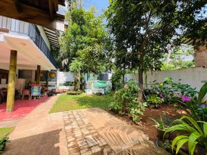 a garden with a tree and a building at Ancient Tree in Mirissa