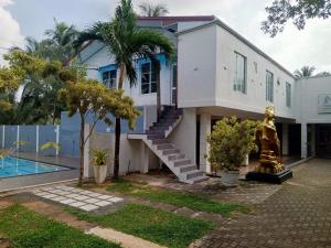 a house with a staircase next to a pool at Hotel Friendstar in Minuwangoda