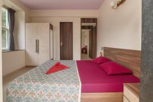 una camera da letto con un grande letto con cuscini rosa di Hemgiri - 6BHK Pool Garden Luxury Villa Girivan Mulshi near Pune Mumbai a Kolvan