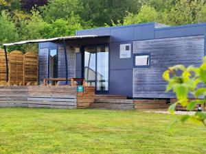 a blue tiny house in a garden at Mobil-home de 32m² avec terrasse et équipements de cuisine - API-1-52-1126 in Loudéac