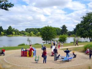 a group of people at a park with a playground at Mobil-home de 32m² avec terrasse et équipements de cuisine - API-1-52-1126 in Loudéac +2 photos