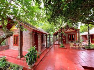 Una casa de ladrillo con un patio de ladrillo rojo con árboles. en TAM FAMILY HOMESTAY and RESTAURANT, en Ninh Binh